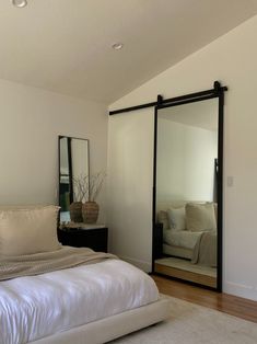 a bedroom with a bed, mirror and couch