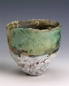 a green and white bowl sitting on top of a table