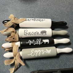 four black and white kitchen utensils with farm animals on them are sitting next to each other