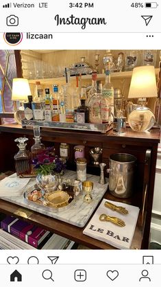 an assortment of liquor bottles and other items on a table in front of a mirror