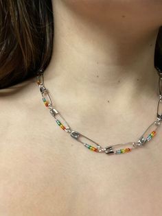 a woman wearing a necklace with multi colored beads