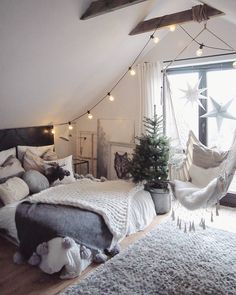 a bedroom with a hammock hanging from the ceiling and lights on the windowsill