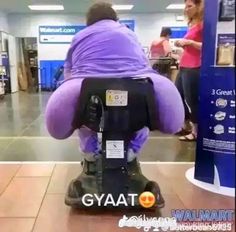 a large purple stuffed animal sitting on top of a machine in a store floor next to two women