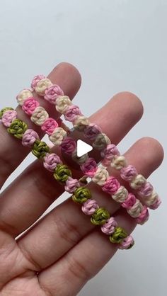 a hand holding three bracelets made out of crochet