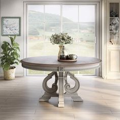 a dining room table sitting in front of a window with potted plants on it