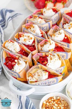 strawberry shortcakes with whipped cream on top and other toppings in small bowls