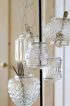 several glass jars with forks and spoons hanging from them