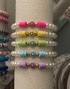 a stack of bracelets with different colored beads and smiley faces on them, sitting next to each other