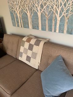 a couch with two pillows and a painting on the wall