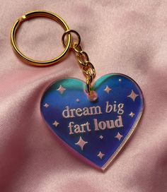 a heart shaped keychain that says, dream big far loud