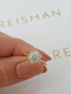 a woman's hand holding an engagement ring in front of a box with the words presiman on it