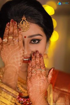 a woman with her hands in front of her face and eyes covered by henna