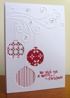 a christmas card with ornaments hanging from it