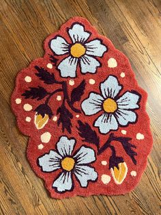 a red rug with white and blue flowers on it