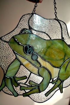 a stained glass frog hanging from a chain