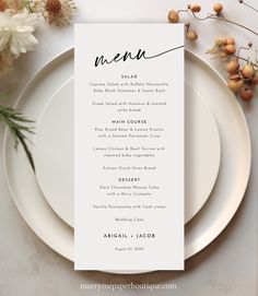 a white plate topped with a menu next to flowers