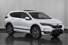 a white honda suv parked in front of a wall