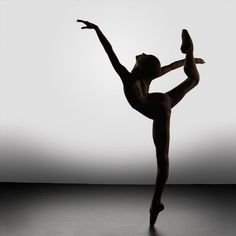 a ballerina in the middle of an artistic dance pose