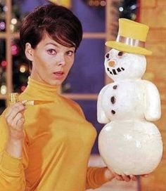 a woman holding a snowman in front of her face