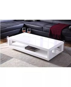 a white coffee table with two wine glasses on it