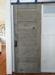 an open wooden door in a room with hardwood flooring and white walls on the wall