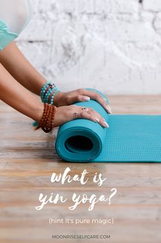 a woman doing yoga on a blue mat with the words what is yin yoga?