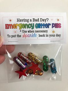 someone is holding up a pack of emergency glitter pins