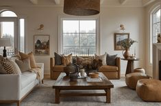 a living room filled with furniture and a fire place in front of two large windows