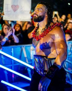 a man with a beard and no shirt standing in front of a crowd