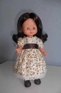 the doll is wearing a dress with flowers on it