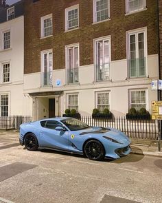 a blue sports car parked in front of a building