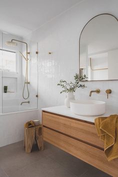 a bathroom with a sink, mirror and bathtub in it's own area