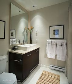 a bathroom with a toilet, sink and mirror in it's centerpieces