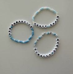 three beaded bracelets with the word'love'written in black and white letters