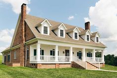 a large white house sitting on top of a lush green field