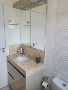a bathroom with a sink, mirror and toilet paper dispenser in it