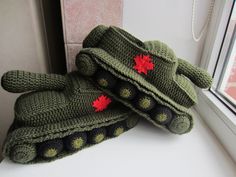 two crocheted mittens sitting on top of a window sill