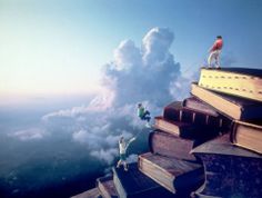 some people are standing on top of books in the sky