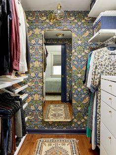 a walk in closet with blue and gold wallpaper