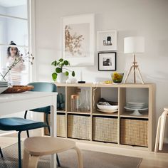 a white table with baskets and pictures on the wall