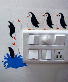 four penguins are standing on the light switch