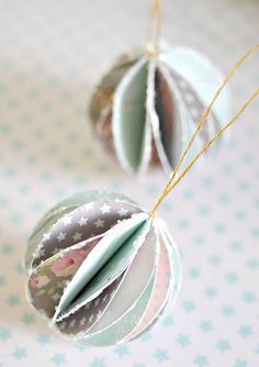 two ornament ornaments hanging from strings on a table