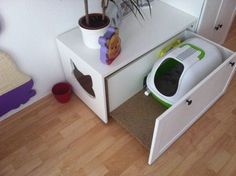 a white microwave oven sitting on top of a wooden floor next to a potted plant