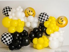 balloons are arranged in the shape of smiley faces and checkered black and white balls