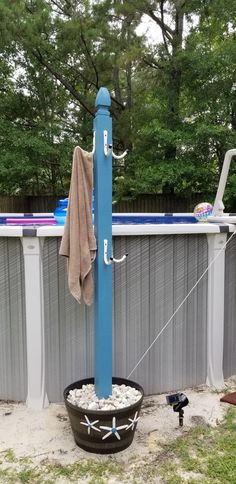 a blue pole is next to a swimming pool with a towel hanging from it's side