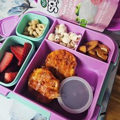 a lunch box with fruit, nuts and yogurt