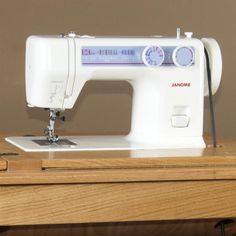 a white sewing machine sitting on top of a wooden table