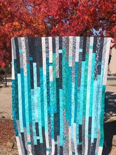 a blue and black quilt sitting on top of a tree