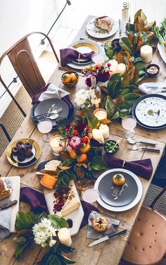 the table is set with plates, silverware, and flowers on top of it