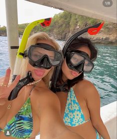 two women in bikinis on a boat wearing scuba gear and snorkels